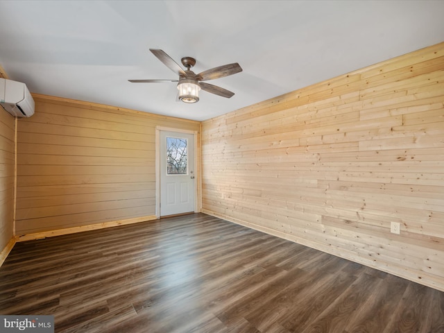 spare room with a wall mounted air conditioner, wood walls, and dark wood-type flooring