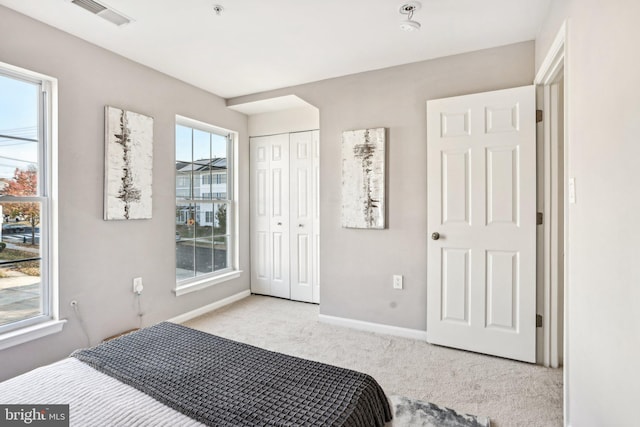 bedroom featuring light colored carpet and a closet