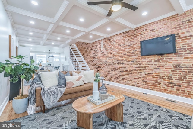 living room featuring ornamental molding, brick wall, ceiling fan, wood-type flooring, and beamed ceiling