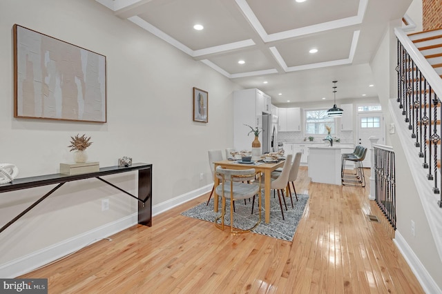 dining area featuring beamed ceiling, light hardwood / wood-style floors, and coffered ceiling