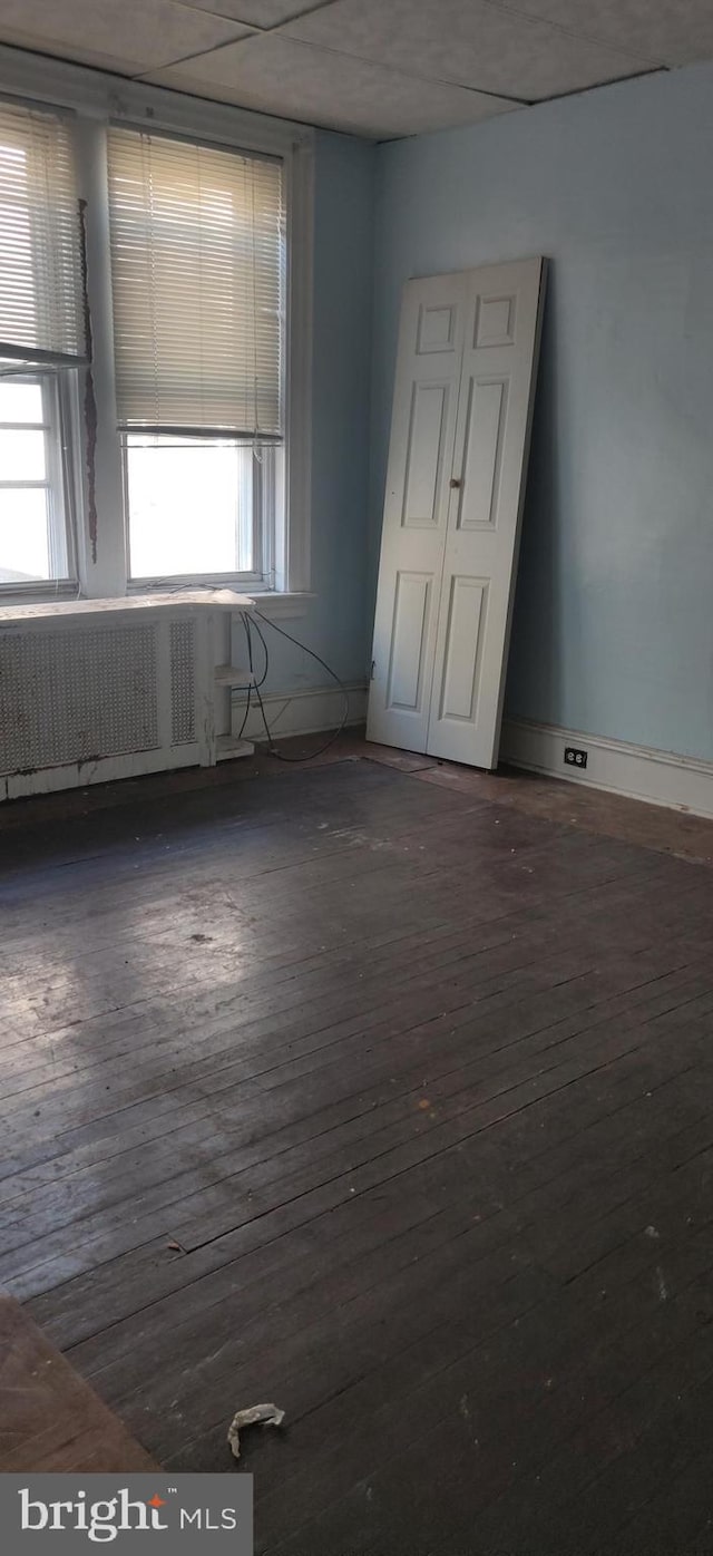 spare room with radiator and dark hardwood / wood-style floors