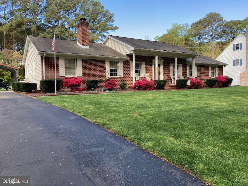 view of front of home with a front yard and covered porch