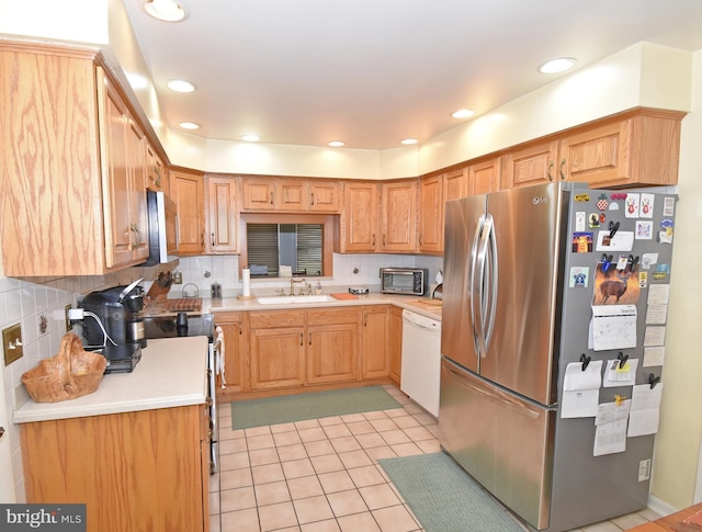 kitchen featuring backsplash, light tile patterned floors, sink, and appliances with stainless steel finishes