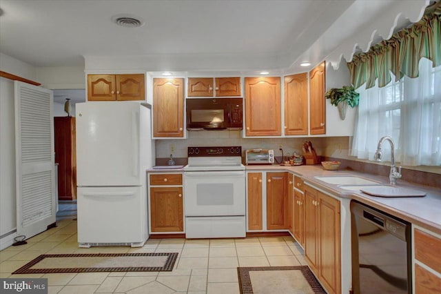 kitchen with light tile patterned floors, sink, and black appliances