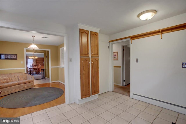 kitchen featuring an inviting chandelier, light tile patterned floors, hanging light fixtures, and a baseboard heating unit