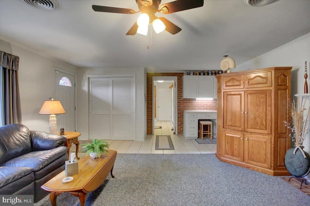 living room with ceiling fan, ornamental molding, and light tile patterned flooring