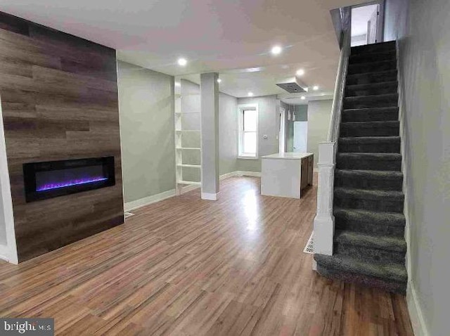 213 N Ramsey St, Philadelphia, PA 19139 - unfurnished living room featuring recessed lighting, a glass covered fireplace, wood finished floors, baseboards, and stairs