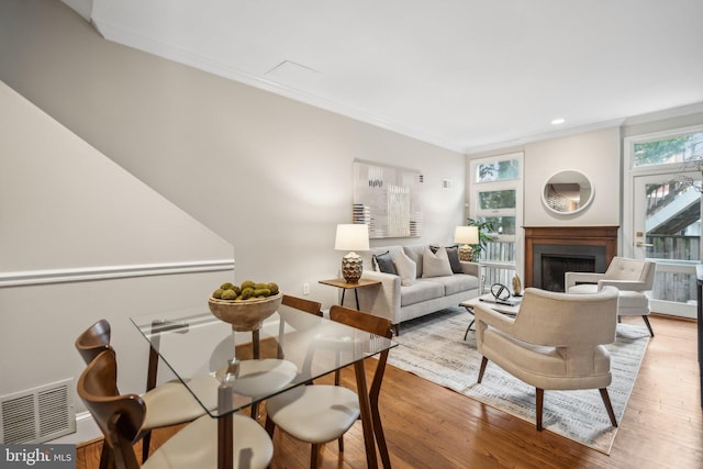 living room with crown molding and light hardwood / wood-style flooring