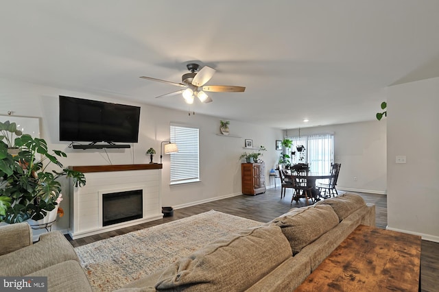 living room with dark hardwood / wood-style flooring and ceiling fan