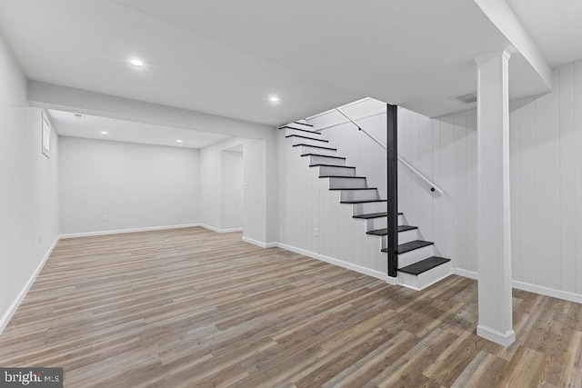 basement featuring wood walls and wood-type flooring