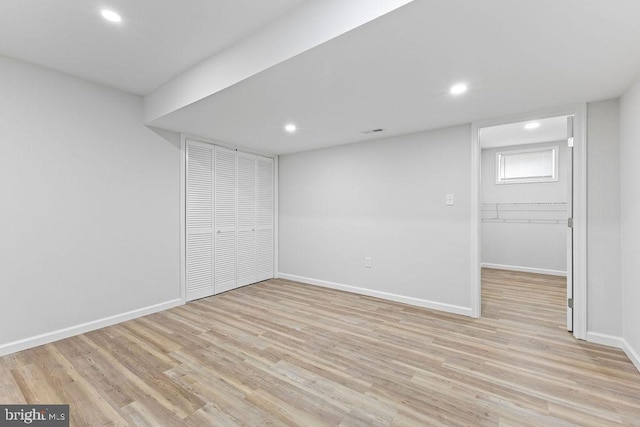 basement with light hardwood / wood-style flooring