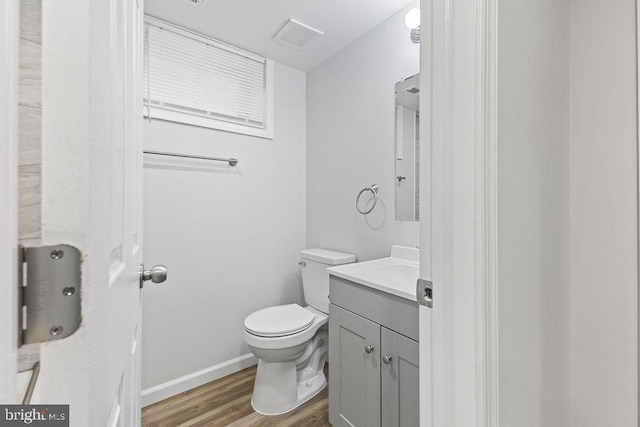 bathroom with hardwood / wood-style flooring, vanity, and toilet