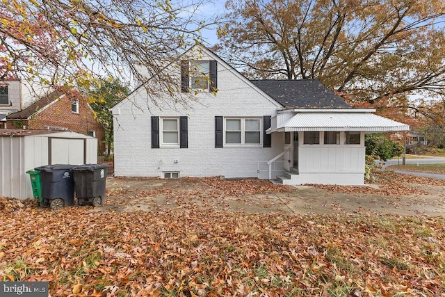 view of front of property featuring a storage shed