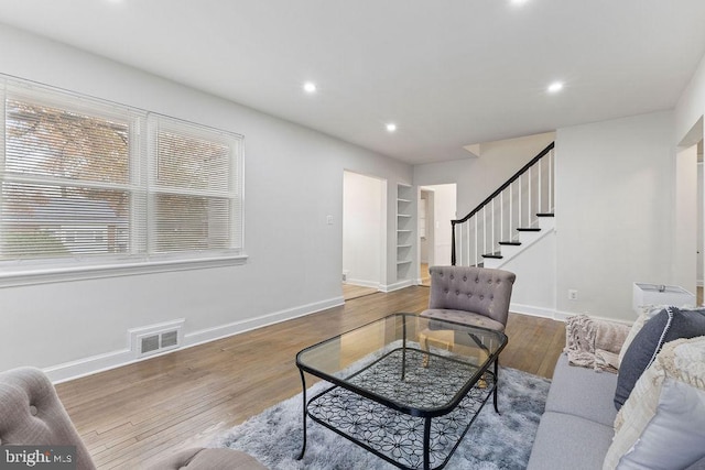 living room featuring hardwood / wood-style floors and built in shelves