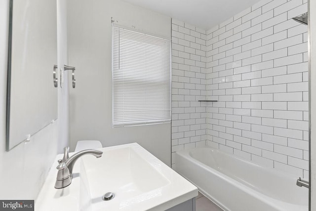 full bathroom featuring sink, tiled shower / bath combo, and toilet