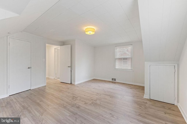 bonus room with light hardwood / wood-style floors and vaulted ceiling