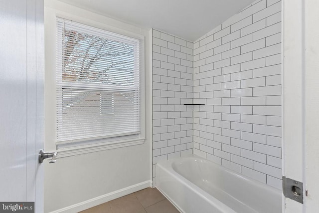 bathroom with tile patterned flooring, vaulted ceiling, and tiled shower / bath