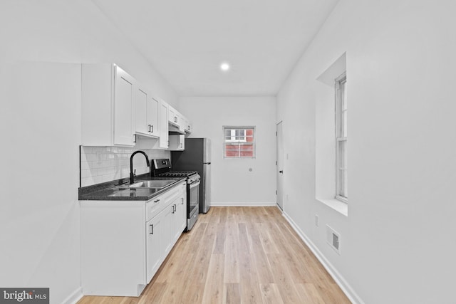 kitchen featuring white cabinets, light hardwood / wood-style floors, sink, and stainless steel range with gas stovetop