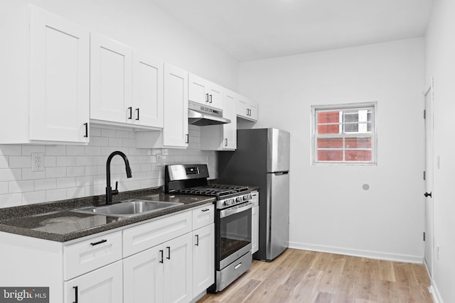 kitchen featuring sink, stainless steel appliances, tasteful backsplash, white cabinets, and light wood-type flooring