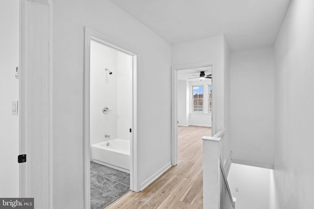 bathroom featuring shower / bathtub combination, hardwood / wood-style floors, and ceiling fan