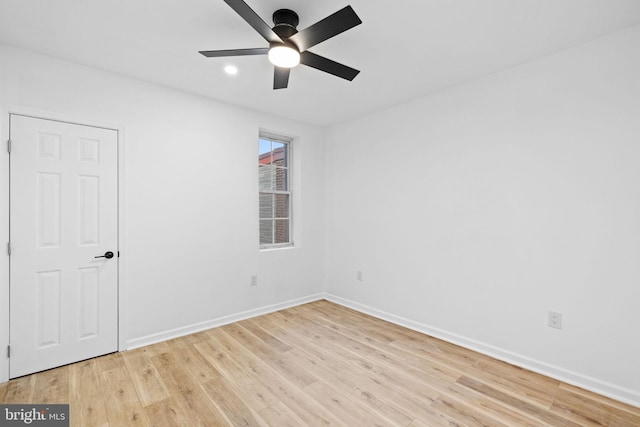 empty room with ceiling fan and light hardwood / wood-style flooring