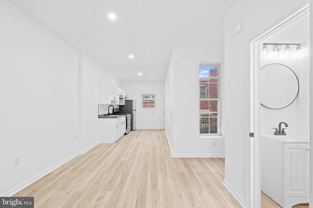 corridor with light hardwood / wood-style floors