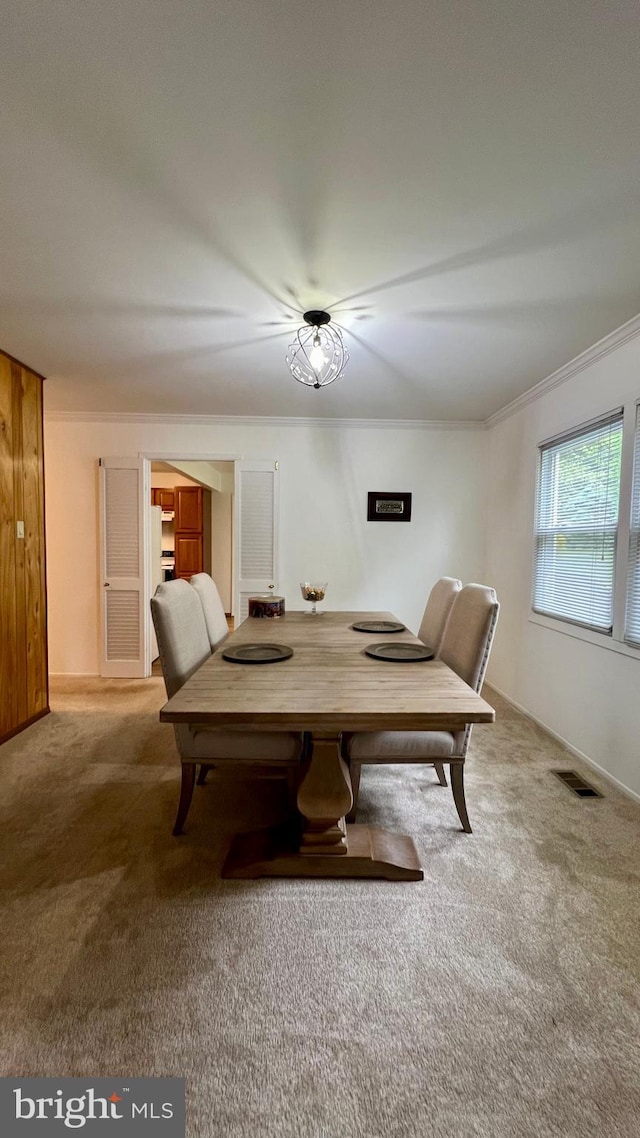 dining space with crown molding and carpet floors