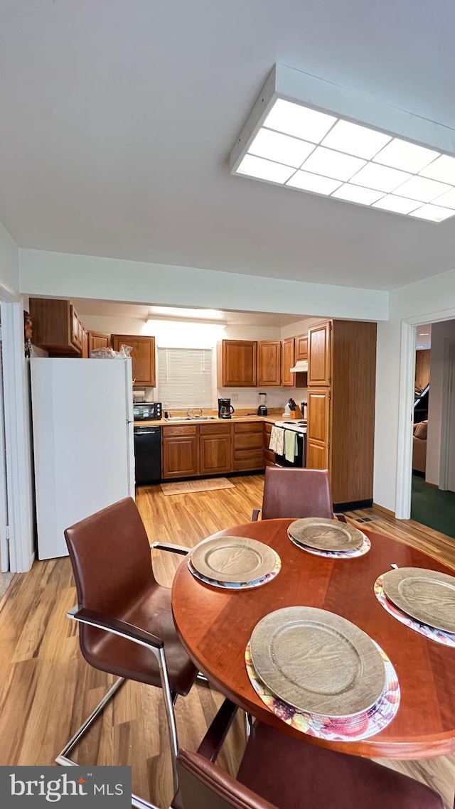 dining room with light hardwood / wood-style floors and sink