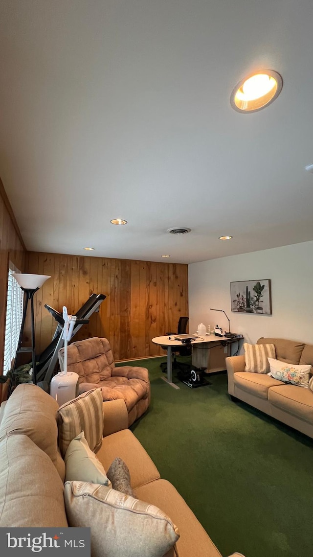 carpeted living room with wood walls