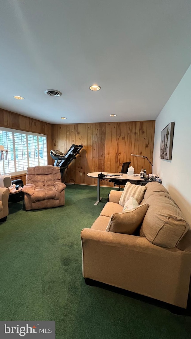 carpeted living room featuring wooden walls