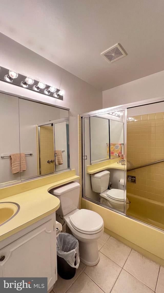 full bathroom featuring tile patterned flooring, vanity, toilet, and combined bath / shower with glass door