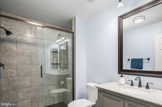 bathroom with vanity, toilet, and an enclosed shower