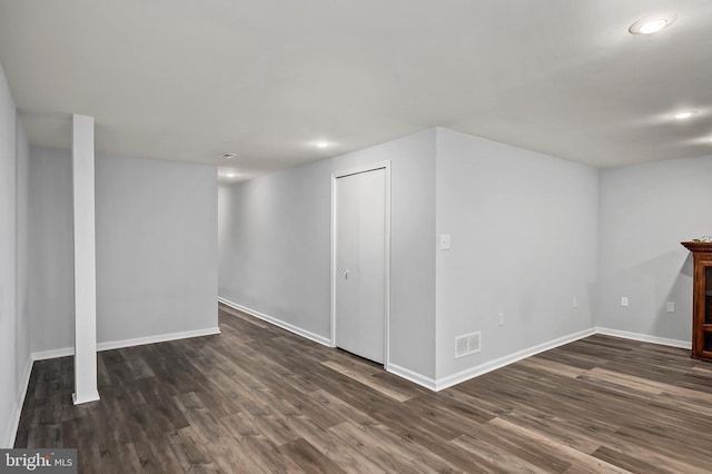 basement with dark hardwood / wood-style floors