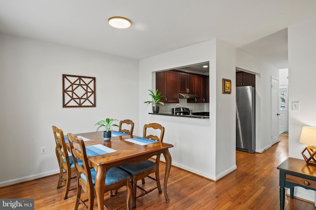 dining area featuring wood-type flooring and sink