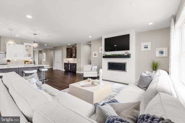 living room featuring dark hardwood / wood-style floors and an inviting chandelier