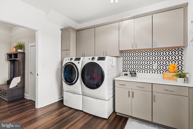 laundry area featuring cabinets, dark hardwood / wood-style flooring, and washing machine and clothes dryer