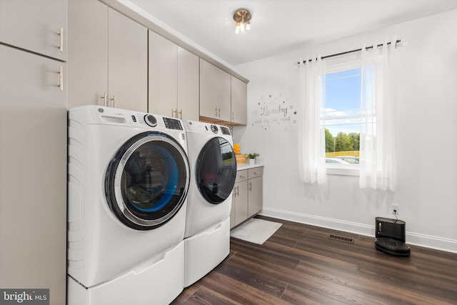 laundry room with cabinets, independent washer and dryer, and dark wood-type flooring