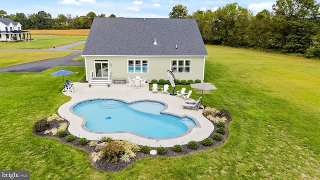 view of pool with a patio area and a lawn