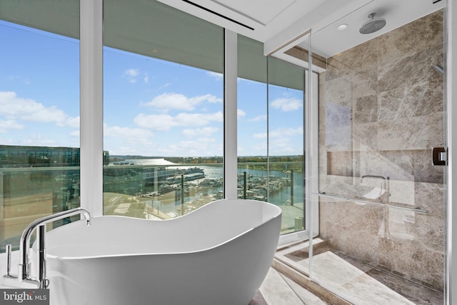 bathroom featuring a water view, tile walls, and plus walk in shower