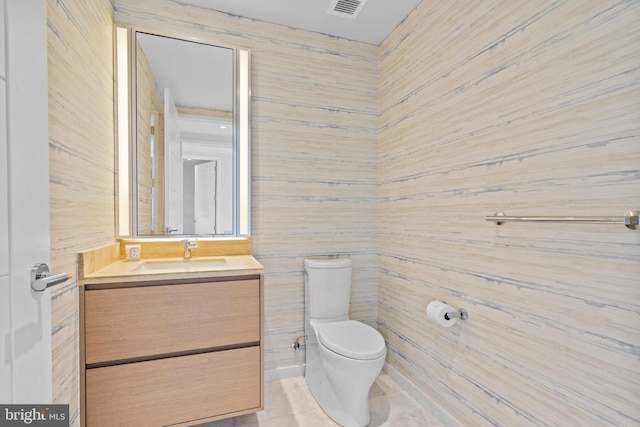 bathroom with vanity, toilet, and wooden walls