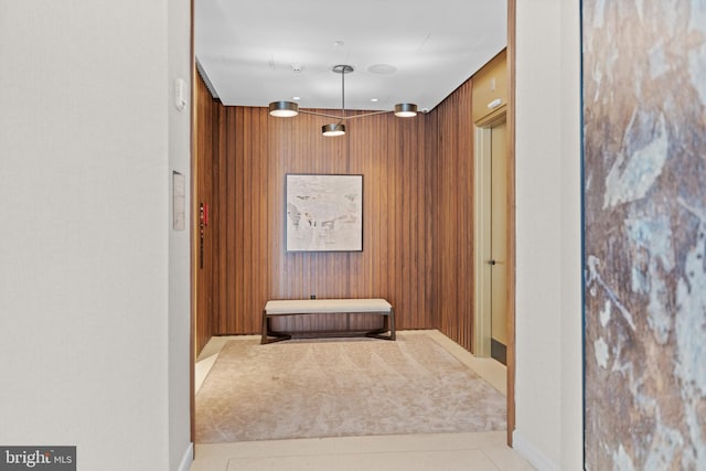 hallway featuring wood walls