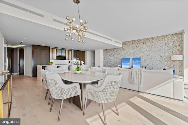 dining area featuring light hardwood / wood-style floors and a notable chandelier