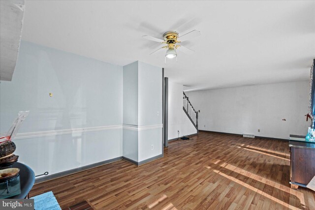 unfurnished living room featuring ceiling fan and dark hardwood / wood-style flooring