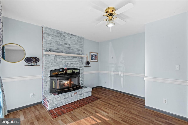 living room with ceiling fan, dark hardwood / wood-style flooring, and a wood stove