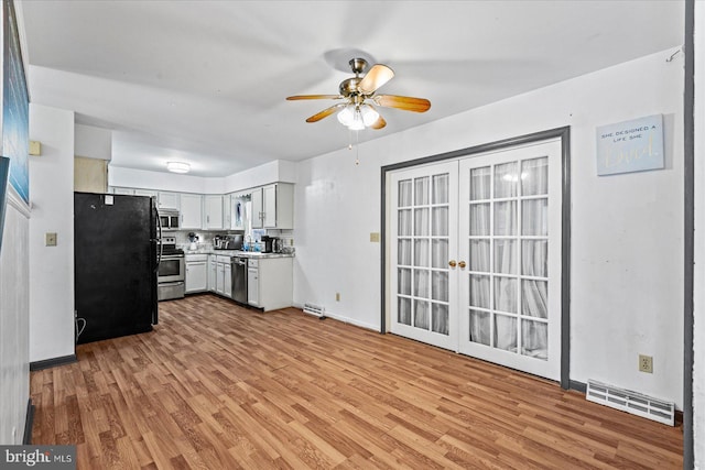 kitchen featuring white cabinets, light wood-type flooring, stainless steel appliances, and ceiling fan