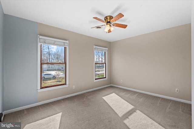 empty room with light colored carpet, plenty of natural light, and ceiling fan