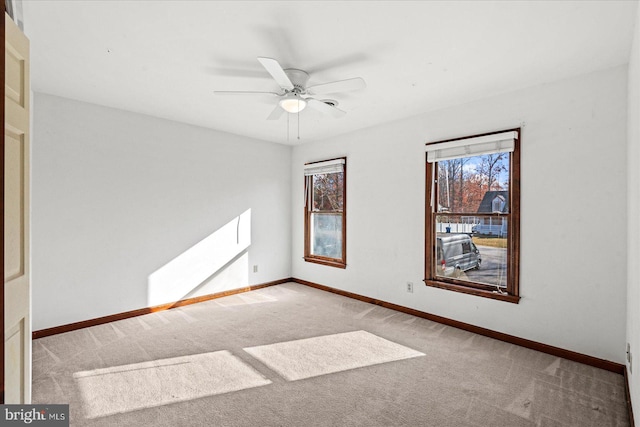 empty room featuring ceiling fan and light carpet