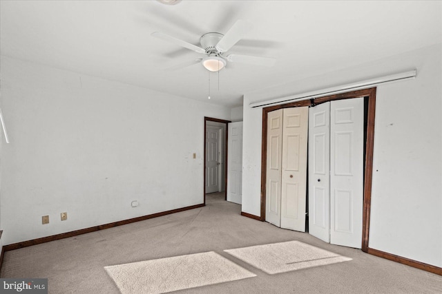 unfurnished bedroom featuring ceiling fan, a closet, and light colored carpet