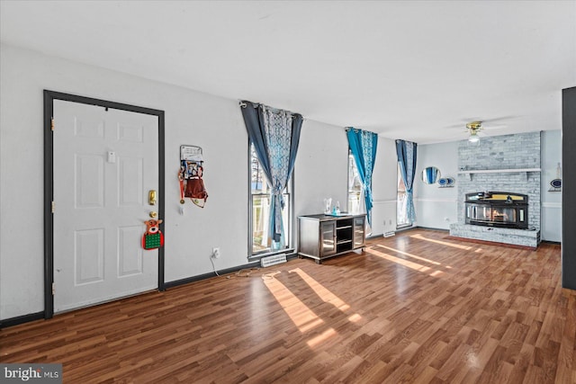 foyer featuring a fireplace, ceiling fan, and hardwood / wood-style floors