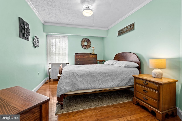 bedroom with a textured ceiling, light hardwood / wood-style floors, ceiling fan, and ornamental molding